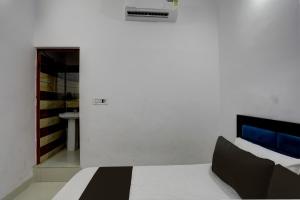 Jest to biały pokój z łóżkiem i łazienką. w obiekcie OYO HOTEL KAVYA RESIDENCY w mieście Aligarh