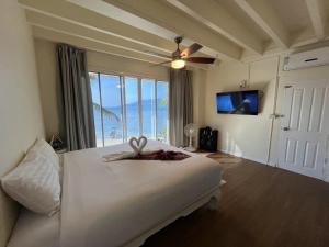 巴東海灘的住宿－AT SEA Patong，一间卧室设有一张大床和大窗户