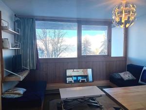 sala de estar con ventana grande y TV en Résidence Cachette - Superbe 2 pièces cabine 4 personnes à Arc 1600, proche des pistes et proche des commerces MAE-7831, en Arc 1600