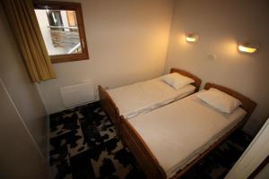 two beds in a small room with a window at Chalets De La Vanoise - 2 Pièces pour 4 Personnes 171 in Villarodin-Bourget
