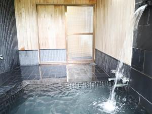 d'une baignoire avec une fontaine. dans l'établissement ～みらい荘～　天然温泉付き一日一組様限定の６４坪広々民泊別荘, à Kirishima 37 autres photos