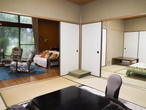 - un salon avec un canapé et une chambre dans l'établissement ～みらい荘～　天然温泉付き一日一組様限定の６４坪広々民泊別荘, à Kirishima