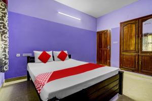 um quarto com uma cama grande e paredes roxas em OYO Flagship Paradise villa em Cherai Beach