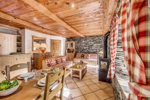 a dining room and living room with a table and a kitchen at Chalet Les Champs Du Pont - Chalets pour 15 Personnes 591 in Tignes