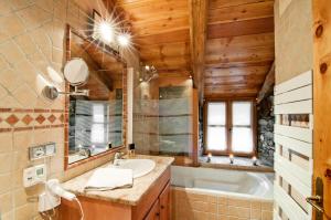 a bathroom with a tub and a sink and a mirror at Chalet Les Champs Du Pont - Chalets pour 15 Personnes 611 in Tignes