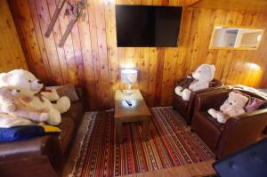 two teddy bears sitting on chairs in a living room at Chalet Pre Saint-jacques - Chalets pour 15 Personnes 601 in Tignes