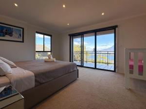 Oceanview Chic Villa 20 min to CBD في Old Beach: غرفة نوم بسرير كبير ونافذة كبيرة