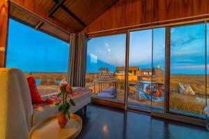 a living room with a large window with a view at KAY PACHA LODGE lago titicaca All Inclusive in Puno