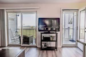 a living room with a television and a balcony at Bethany Ocean View Condo by the sea 1st of 2 in Ocean View +20 photos