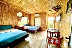a bedroom with two beds and a desk and a bed at The Pineapple House in Ninh Binh