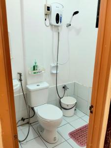 a bathroom with a toilet and a blow dryer at Catalena Transient House Bayugan City in Bayugan City