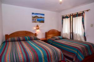 1 dormitorio con 2 camas y ventana en Hostal Cultural Bertha Challapampa Isla del Sol parte Norte en Comunidad Challapampa