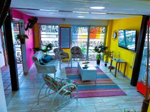 a lobby with colorful walls and chairs and a table at Aparta Hotel Bacano Historico in Santa Marta