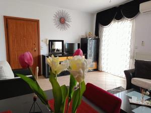 a living room with a couch and a table with flowers at Layla Home in Alexandroupoli