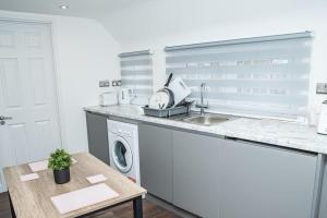 a kitchen with a sink and a washing machine at Aylesbury Studio Apartment 6 with parking in Buckinghamshire