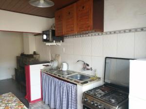 a small kitchen with a sink and a stove at Casita céntrica in Trinidad