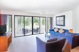 バンタオビーチにあるHomm Suites Lagunaのリビングルーム(青いソファ、椅子付)