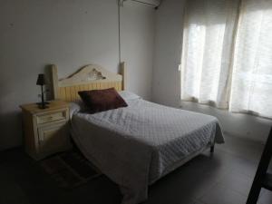 um quarto com uma cama, uma mesa de cabeceira e uma janela em Casita céntrica em Trinidad