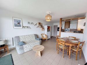 een woonkamer met een bank en een eettafel bij Appartement Jullouville, 2 pièces, 4 personnes - FR-1-361-45 in Jullouville-les-Pins