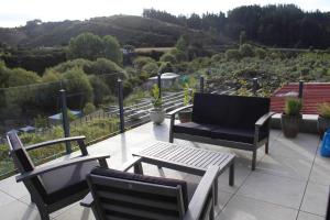 a patio with chairs and a couch and a table at Maymorn Orchard Suite in Upper Hutt