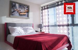 um quarto com uma cama com um cobertor vermelho e uma janela em HOTEL CALICOMFORT em Tecate