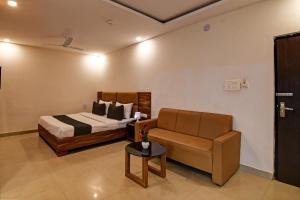 ein Schlafzimmer mit einem Bett, einem Sofa und einem Tisch in der Unterkunft Nilay classic in Bārang
