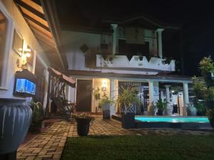 a house with a swimming pool at night at Lukshmie Villa in Ja-Ela
