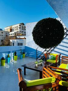 d'une terrasse avec une table et des chaises sur un balcon. dans l'établissement Votre refuge paisible, à Chefchaouen