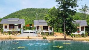 uma casa com uma piscina em frente em พรพนาฮิลล์รีสอร์ท em Ban Makok