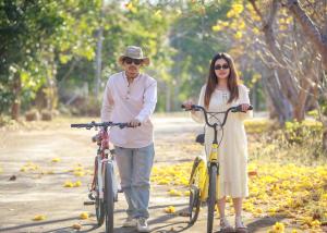um homem e uma mulher a andar de bicicleta em พรพนาฮิลล์รีสอร์ท em Ban Makok
