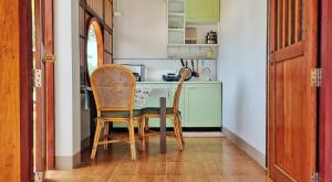 พรพนาฮิลล์รีสอร์ท في Ban Makok: غرفة طعام مع طاولة وكرسيين