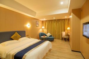 ein Hotelzimmer mit einem Bett und einem TV in der Unterkunft Green Island Holiday Hotel in Jiangmen