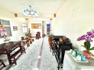 Xingang的住宿－新港風情民宿，客厅配有木桌和紫色鲜花