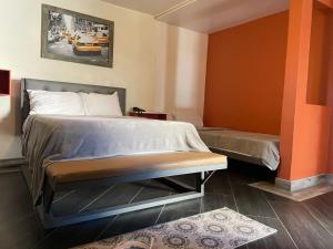 HOTEL CALICOMFORT في تيكاته: سرير في غرفة بجدار برتقالي