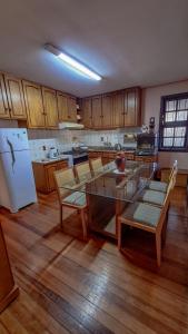 a kitchen with a table and chairs and a refrigerator at Quarto Aconchegante na - Peniel Guesthouse in Gramado