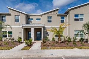 ein Haus mit Palmen davor in der Unterkunft 4321 QS - Magical Haven Townhome w Pool in Kissimmee