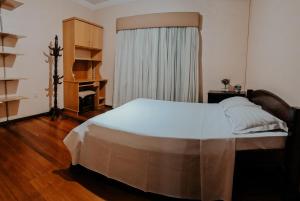 a bedroom with a large bed and a window at Quarto Aconchegante na - Peniel Guesthouse in Gramado