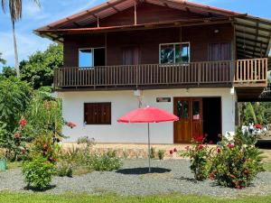 a red umbrella in front of a house at Cabañas Iracas del Mar in Nuquí