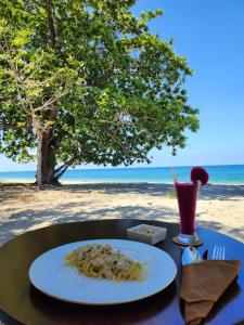 - une assiette de pâtes sur une table sur la plage dans l'établissement KANDORA Luxury villas, à Maujawa