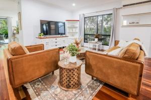 a living room with two couches and a table at Agnes Bliss - Stunning, Central Four-Bedroom Beach House in Sunny Agnes Water in Agnes Water