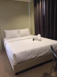 - un lit avec 2 serviettes et 2 tasses dans l'établissement Spacious Studio Apartment B203, à Manille
