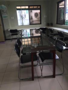 une salle à manger avec une table et des chaises en verre dans l'établissement Spacious Studio Apartment B203, à Manille
