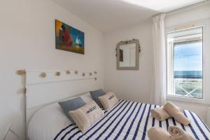 una camera da letto con un letto a strisce blu e bianche di L'Evasion Bleue * WIFI * Bord de mer * Piscine * a Cap d'Agde