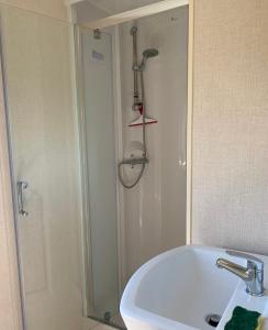 a bathroom with a shower and a white sink at Mobile home Cc780 Siblu Les Charmettes close to the sea in Les Mathes