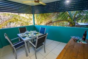a dining room with a table and chairs and a blue wall at Beach Pad 2 - Modern 2-bed unit by the beach in Agnes Water