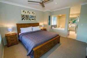 a bedroom with a large bed and a bathroom at Beach Pad 2 - Modern 2-bed unit by the beach in Agnes Water