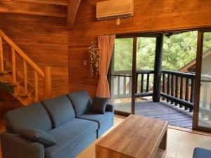 a living room with a blue couch and a table at 徳島 So-Cal Wajiki Base -Tokushima- in Kawaguchi
