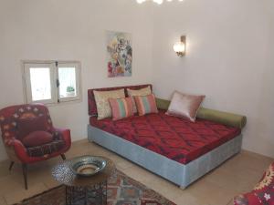 a bedroom with a bed and a chair and a table at Luxury studio at the heart of old Jaffa in Tel Aviv
