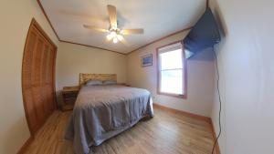 a bedroom with a bed and a ceiling fan at River Dream Lake Murray Getaway in Saluda