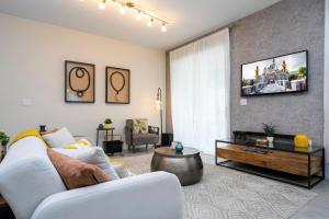 uma sala de estar com um sofá branco e uma televisão em 4810 LL - 5BD Private Pool Townhome - Storey Lake em Kissimmee